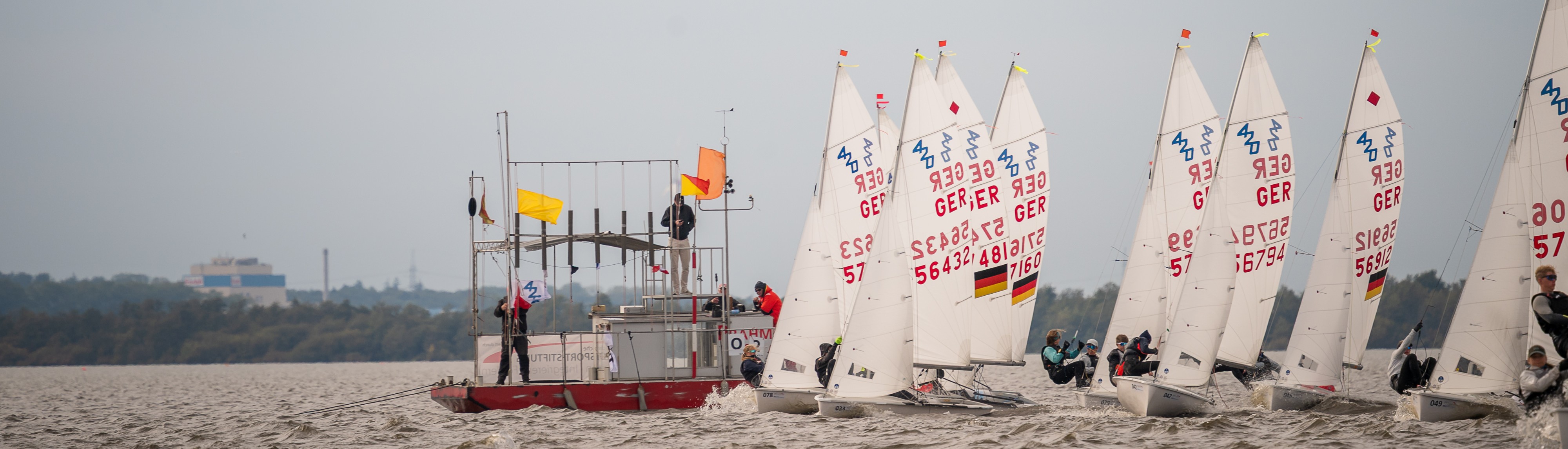 420er beim Regattastart, Wettfahrtleitung mit Flaggensignalen im Vordergrund